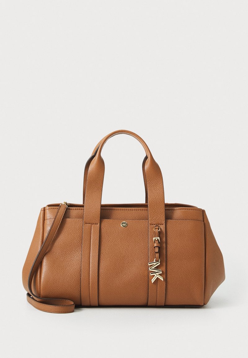 Sac à main en cuir marron avec doubles poignées, une bandoulière amovible et un pendentif logo MK doré à l'avant.