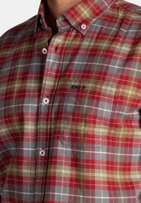 Rood, groen en grijs geruit overhemd met knopen, een kraag, een borstzak en witte knopen met subtiele branding op de zak.