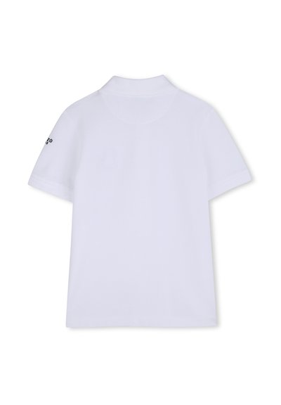 Polo blanco de manga corta con cuello acanalado y pequeño logo negro en la manga izquierda, visto desde atrás.