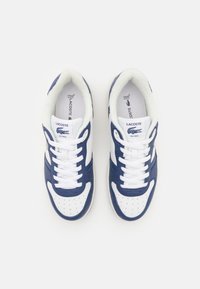Zapatillas Lacoste que presentan una combinación de colores blanco y navy, cuero suave, punta redonda, detalle perforado y cordones blancos.