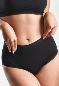 Mutande nere a vita alta con una texture morbida, cuciture minime e un elastico liscio in vita, che mostrano un design elegante e senza fronzoli.