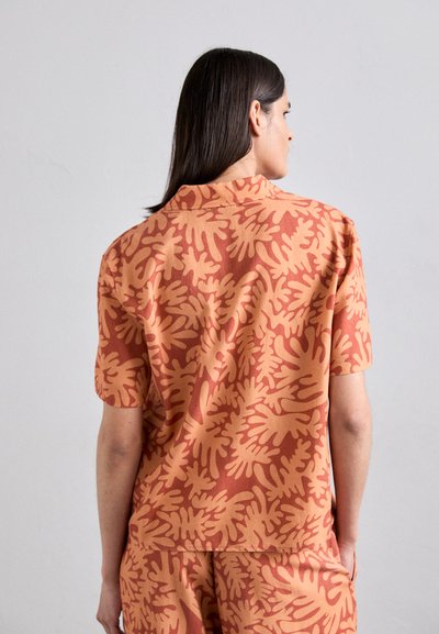 Short-sleeve shirt in warm orange with swirling plant patterns, crafted from lightweight fabric, featuring a classic collar and relaxed fit.