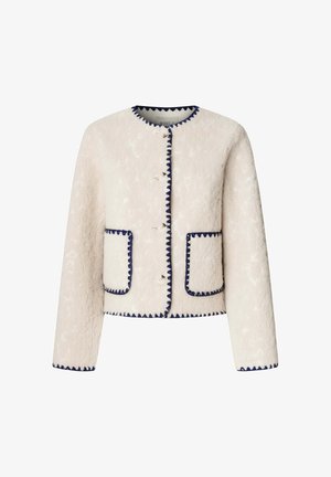 Giacca in pile crema con rifiniture blu navy, collo rotondo, bottoni frontali e tasche applicate. Tessuto testurizzato con un aspetto morbido.