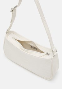 Biała torebka z imitacji skóry z fakturą krokodyla, o prostokątnym kształcie, zamykana na zamek na górze, z regulowanym paskiem. Wnętrze w kolorze beżowym.