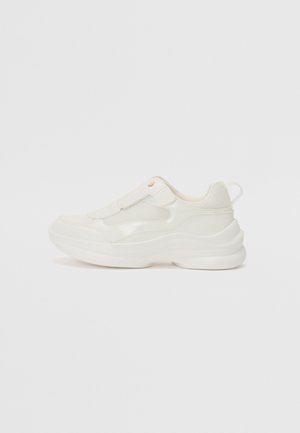 White athletic shoes featuring a smooth synthetic upper, mesh accents, cushioned sole, and a textured design with a back pull tab.