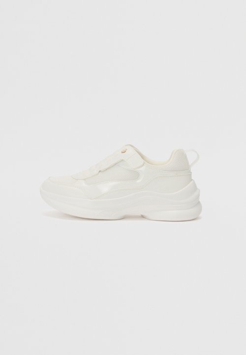 Hvide sportssko med en glat syntetisk overdel, mesh-detaljer, polstret sål og et struktureret design med en bageste trækflap.