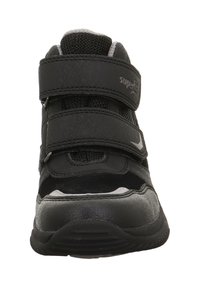 Schwarzer Sportschuh aus Mesh- und synthetischem Leder, ausgestattet mit drei verstellbaren Klettverschlussriemen, gepolstertem Kragen und strukturiertem Außensohle.