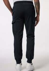 Marineblauwe cargobroek met elastische tailleband en boorden, voorzien van twee zijzakken en een achterzak, gemaakt van een zachte, gestructureerde stof.