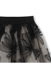 Μαύρη φούστα από τούλι με φαρδιά ελαστική μέση που φέρει διάκοσμο από παγιέτες σε σχέδια λουλουδιών πάνω σε μπεζ υπόστρωμα. Ελαφριά και αέρινη υφή.