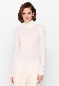 Hellbeige Rollkragenpullover aus weichem, strukturiertem Strickstoff. Mit langen Ärmeln und einem dezenten Farbverlauf am Saum.