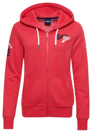 Red zip-up hoodie with white drawstrings, front pockets, and "Super Dry" logo on chest and left sleeve details.