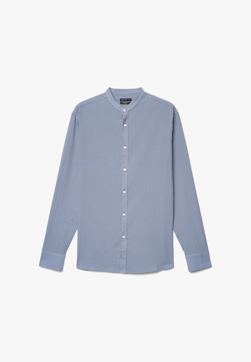 Chemise bleu clair à manches longues avec col mandarin et boutons blancs sur le devant, présentée à plat sur un fond blanc.