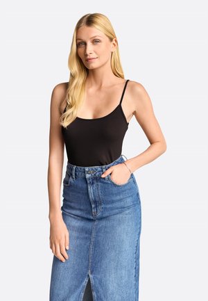 Black sleeveless bodysuit with thin straps, paired with a light blue denim skirt featuring a front slit and five-pocket design.