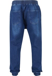 Pantalones jogger de denim con cintura elástica, dos bolsillos traseros, puños ajustados y un lavado azul medio con un ligero desgastado.