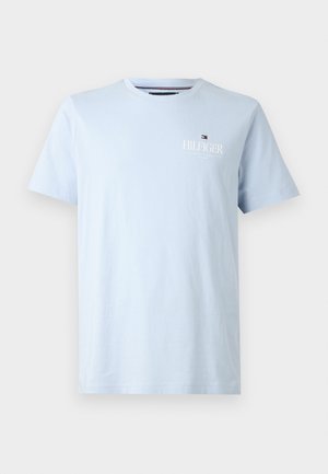 T-shirt bleu clair à manches courtes et col rond avec petit logo blanc Tommy Hilfiger et drapeau sur le côté gauche de la poitrine.