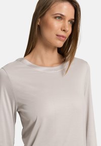 Světle šedý dlouhý rukáv top z hladké tkaniny, s kulatým výstřihem a jemným leskem na límci.