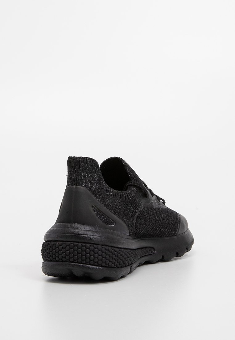 Sneaker atletico nero con suola testurizzata, upper in maglia e chiusura con lacci, visto da dietro su uno sfondo bianco.