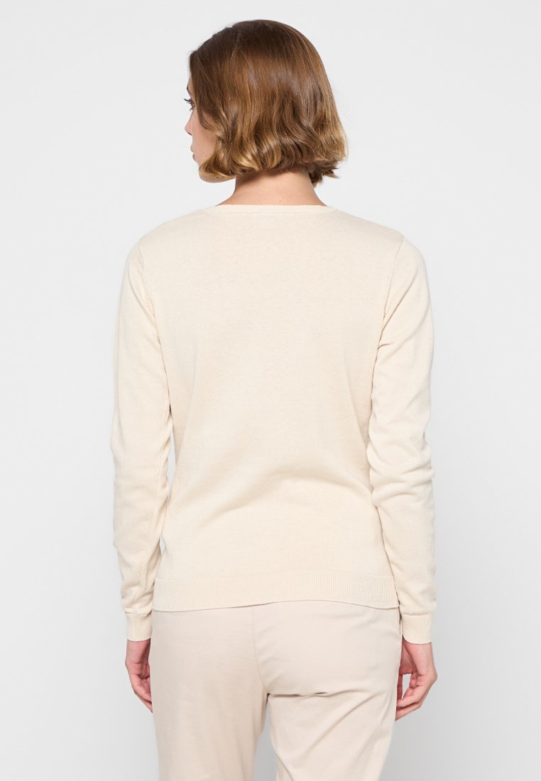 Beige gebreide trui met een ronde hals en lange mouwen. De textuur lijkt zacht, met een geribbelde zoom en manchetten. Achteraanzicht weergegeven.