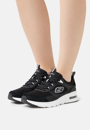 Czarne sneakersy wykonane z połączenia siateczki i zamszu. Posiadają białą podeszwę, sznurówki oraz logo z boku. Białe akcenty na języku.