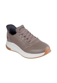 Baskets Skechers en tan et blanc. Dessus en synthétique lisse avec accents texturés, semelle en caoutchouc et fermeture à lacets.