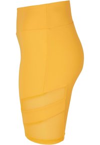 Geel hooggeplooide shorts gemaakt van rekbaar materiaal met een gladde afwerking en een doorschijnend meshpaneel aan de zijkant.