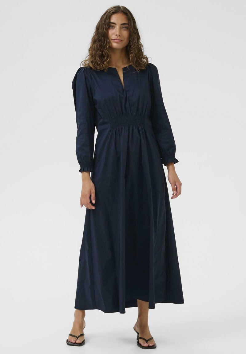 Marineblaues Maxikleid mit gerafftem Taillenbund, langen Ärmeln und V-Ausschnitt. Es hat einen weichen Stoff und eine entspannte, fließende Silhouette.