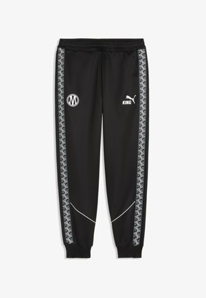 Schwarze Trainingshose mit elastischem Bund, geometrischen Seitenstreifen, weißen KING- und Puma-Logos auf der Vorderseite und gerippten Bündchen an den Knöcheln.