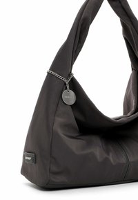 Borsa di stoffa grigio scuro con un design morbido; presenta un manico attorcigliato e un'accenno di catena argento con un'etichetta rotonda del logo. Texture liscia.