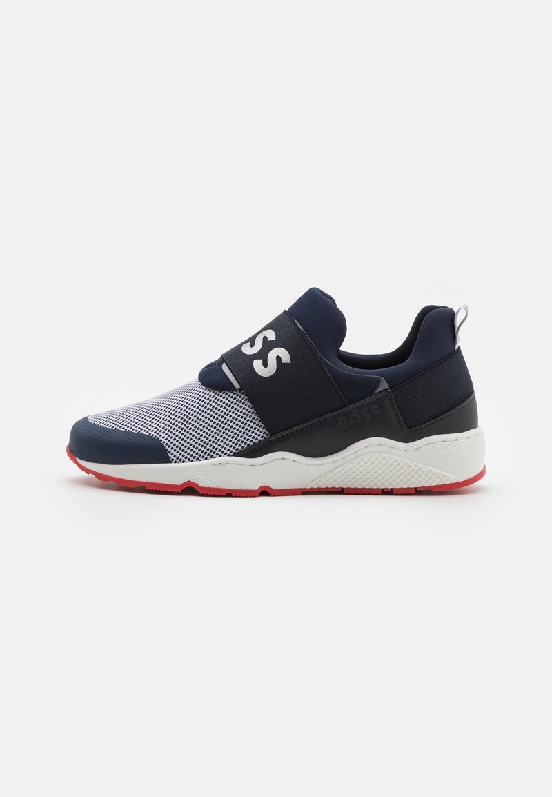 Baskets slip-on bleu marine et blanc avec dessus en mesh, large sangle élastique avec le texte « BOSS », semelle intermédiaire blanche et semelle extérieure en caoutchouc rouge.