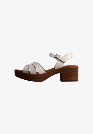 Sandale blanche en cuir à talon bloc en bois, bout ouvert, trois brides avant et bride de cheville réglable avec boucle.