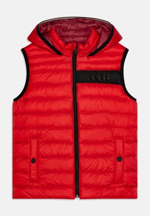 Veste sans manches rembourrée rouge avec fermeture éclair et capuche. Présente un patch logo noir et deux poches latérales avec fermetures à pression. Texture lisse.