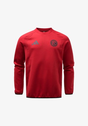 Czerwona sportowa bluza z długim rękawem z czarną lamówką, logo Adidas na prawej piersi i okrągłą emblematem zespołu F95 na lewej piersi.