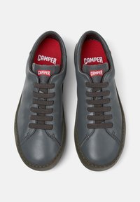 Szare skórzane buty z brązowymi sznurówkami i czerwonym wykończeniem. Charakteryzują się okrągłym czubkiem i kontrastującymi szwami. Logo umieszczone na języku.