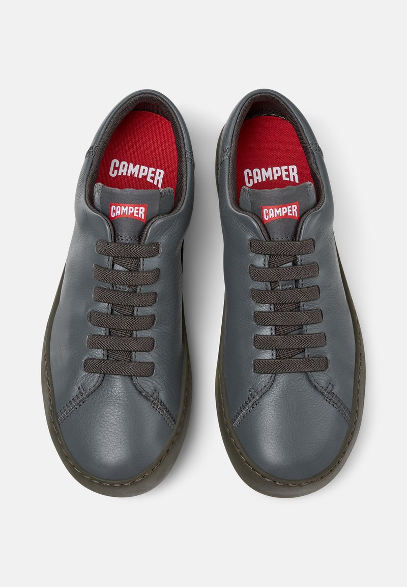 Scarpe in pelle grigia con lacci marroni e rivestimento rosso. Presentano una punta rotonda e cuciture a contrasto. Logo visibile sulla linguetta.