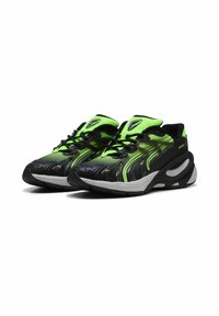 Sorte og neongrønne sneakers har et strømlinet design, tekstureret overdel og buet sål. Snørebånd og accenter fremhæver det sporty udseende.