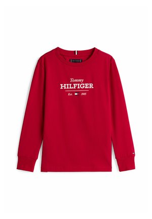T-shirt a maniche lunghe rossa in cotone. Presenta un logo bianco "Tommy HILFIGER" e il testo "Est. 1985" sulla parte frontale. Vestibilità standard.