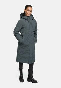 Long, hooded coat in a dark gray, made from a soft, textured fabric. Features a front zipper, large pockets, and a relaxed fit.