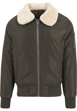 Blouson bomber marron foncé avec fermeture éclair à l’avant, poignets et ourlet côtelés, et un grand col en peau lainée couleur crème.