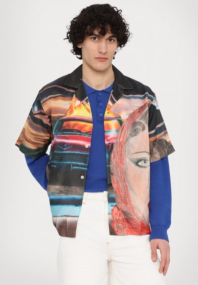Short-sleeve shirt featuring vibrant printed graphics of a face and a car, black collar, and buttons, paired with a blue long-sleeve undershirt.