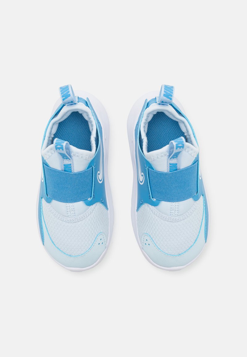 Sneaker azzurri con tomaia in rete testurizzata, suola bianca, cinturino blu regolabile e linguetta posteriore. Progettati per un facile utilizzo.