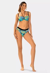 Strój kąpielowy w zestawie składający się z biustonosza typu bustier oraz spodenek z wysokim stanem. Kolorowy tropikalny wzór z czarnymi akcentami, regulowane ramiączka i gładka faktura materiału.