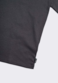 T-shirt grigia a maniche lunghe realizzata in cotone morbido. Presenta un orlo dritto e una piccola etichetta del marchio sul lato sinistro in basso.