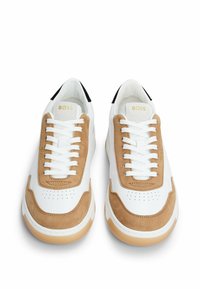 White sneakers with beige suede accents, featuring round toes, flat laces, perforated detailing, and a logo on the tongue.