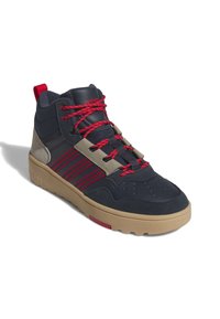 Mörkblå hög sneaker med röda snören, tan sula och grå detaljer. Har perforeringar på tån och randig detalj på sidan.