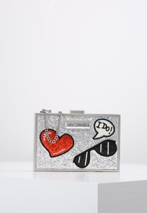 Rechteckige silberglitzer Clutch mit Kette, dekoriert mit rotem Herz, schwarzer Sonnenbrille und Sprechblase mit dem Text „ICH WILL!“