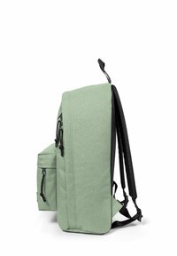 Zaino verde con una finitura testurizzata, tasca laterale, spallacci regolabili e un design minimalista con accenti neri.