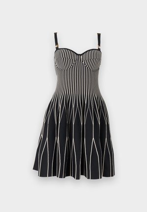 Black sleeveless dress with white vertical and zigzag stripes, fitted bodice, flared skirt, and adjustable shoulder straps with gold-tone hardware.