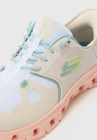 Lightweight athletic shoe in white and pastel blue, featuring mesh fabric, cushioned sole, accent details in green and pink, and logo.