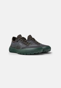 Sneaker in tessuto grigio con suola in gomma verde, caratterizzate da un design in rete, punta tonda e chiusura con lacci. Tallone rinforzato e dettaglio del logo.