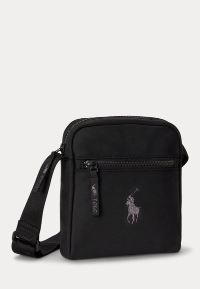 Black crossbody bag with adjustable strap, front zip pocket, and embroidered polo player logo on the front.